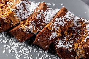 Chocolate sponge cake roll sprinkled with coconut