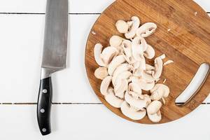 Chopped Mushrooms on the round wooden cutting board
