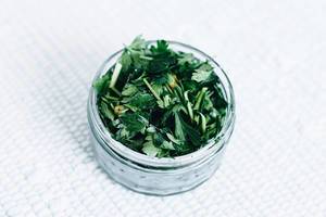 Chopped parsley in a jar . Close up