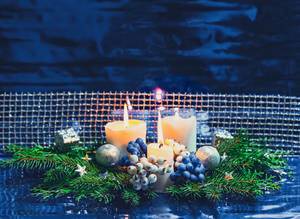 Christmas background with burning candles, Christmas tree branches, gifts and new year toys