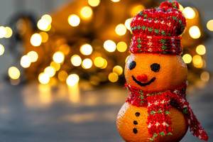 Christmas background with snowman made from tangerines and bokeh luminous garlands (Flip 2019)