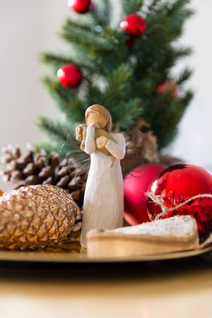Christmas season decoration with angel figure next to christmas tree balls and fir cones