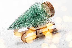 Christmas tree on a wooden sleigh on the background of snow. Christmas background with bokeh (Flip 2019)