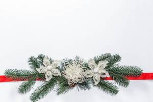 Christmas white background with Christmas tree branches, decor and red ribbon
