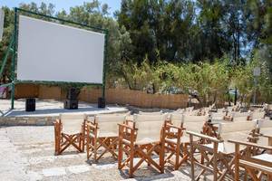 Cinema Enastron, an open air movie theater venue under the stars, for retro movies, with wooden chairs, at  Park Paros, Greece