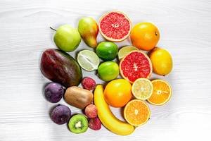 Circle of fresh fruit on white wooden background. Top view