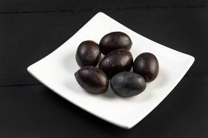 Cleaned Black Olives served on the square plate