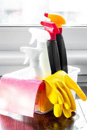 Cleaning products with rubber gloves in the kitchen by the window