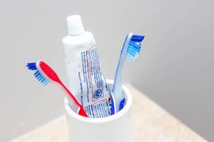 Close Up Bokeh of Toothbrushes and Toothpaste in a cup
