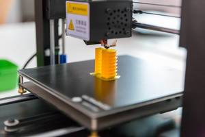 Close Up Bokeh Photo of Anycubic I3 Mega 3D Printer printing a yellow Piece