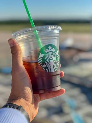 Close Up Bokeh Photo of Hand holding a Plastic Cup with Starbucks Cold Brew Coffee with Plastic Straw