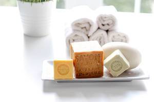Close Up Bokeh Photo of Natural Soap in different Shapes with Towels and Flower Pot in the Background