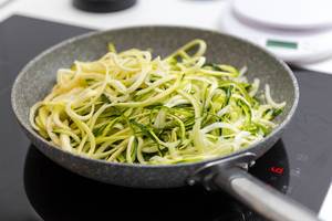 Close Up Bokeh Photo of Pan with Zoodles Zucchini Noodles standing on Stove