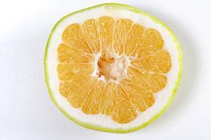Close-up eine Hälfte von einer Zitrone Sweetie Oroblanco auf weißem Hintergrund