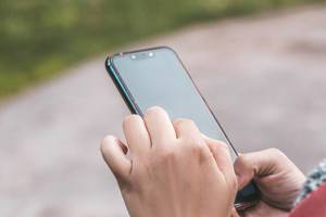 Close-up, female hands holding a smartphone on the street background