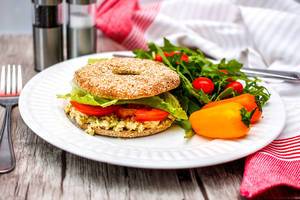 Close Up Food Photo of Bagel with Egg Salad, Arugula, Bell Pepper, Tomatoes and Lettuce