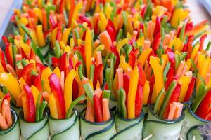Close Up Food Photo of Colorful Pepper Slices rolled up in Cucumber Slices