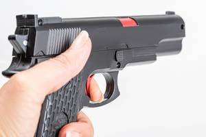 Close up, hand holding black plastic toy gun