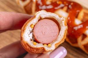 Close-up of a cut Corn Dog in a waffle