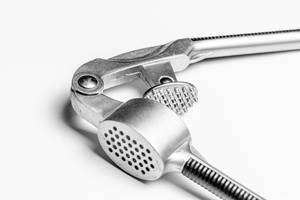 Close up of a garlic press on white background