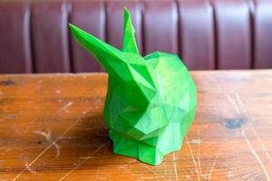 Close-up of a green rabbit created through 3D printing photographed from the front