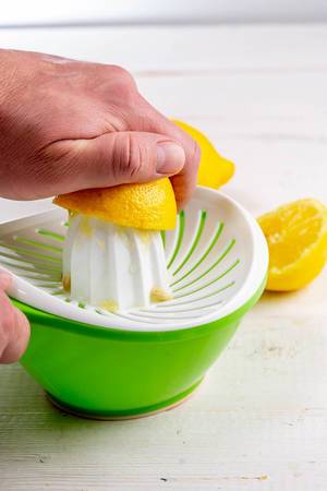 Close-up of a man squeezes juice from a lemon using a hand juicer (Flip 2019)