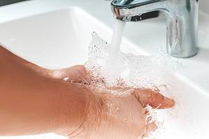 Close up of a man washing his hands and water is pouring from a faucet with spray (Flip 2019)