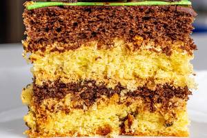 Close-up of a piece of sponge cake with yellow and chocolate biscuits