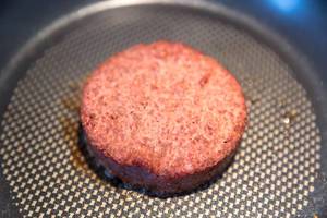 Close-up of a soy-free burger patty by "Beyond Meat" in a pan, as a meat alternative for a vegan lunch