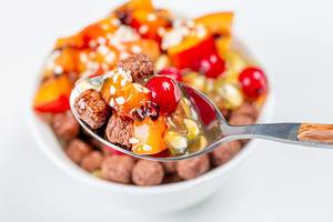 Close-up of a spoon with chocolate corn balls and fruit. The concept of Breakfast (Flip 2020)
