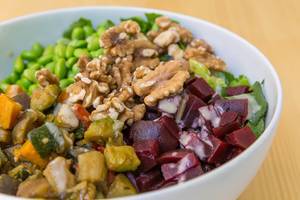 Close-up of a vegan bowl with grilled vegetables, beetroots, walnuts and soy-sesame dressing