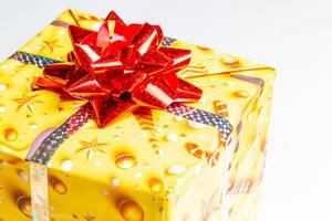 Close-up of a yellow gift box with a red bow