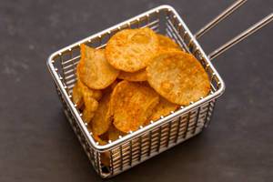 Close-up of athlete snack "Crunchy Protein Potato Chips" with sweet pepper flavour and with high protein content by IronMaxx in a tiny frying basket
