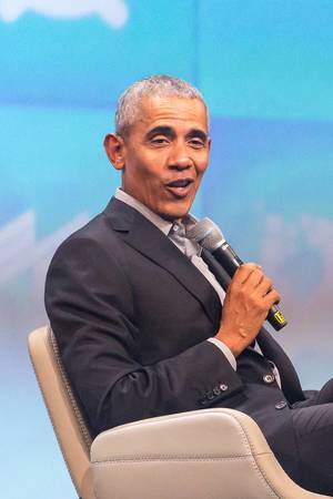 Close-up of Barack Obama with a microphone, talking at a German investors festival to connect within the startup ecosystem