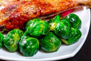 Close-up of Brussels sprouts with baked chicken leg