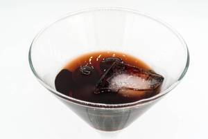 Close-up of cherry brandy with cherries and ice cube