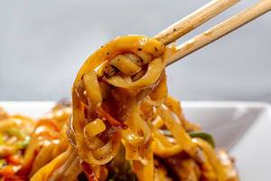 Close up of chinese noodles in spicy sauce and chopsticks