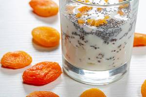 Close up of cottage cheese with yogurt and Chia seeds in a glass with dried apricots