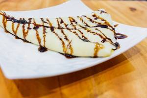 Close up of crepe with chocolate syrup