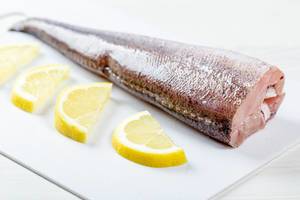 Close-up of fresh heck fish with lemon slices