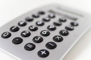 Close-up of grey calculator with black buttons