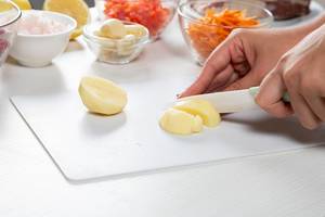 Close-up of hand cut potatoes on the background of sliced and grated vegetables (Flip 2019)