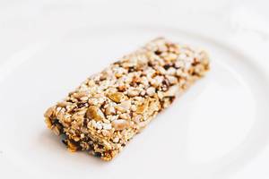 Close up of healthy muesli bar with nuts on white background