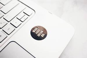 Close up of motivational laptop sticker. Work hard, dream big.