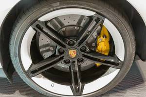 Close-up of Porsche tyres on electric sports car Taycan Turbo S