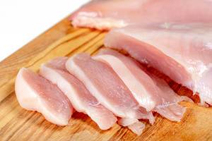 Close up of raw chicken fillet chunks on wooden kitchen board (Flip 2019)