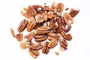 Close up of raw pecan nuts on white background