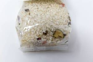 Close up of raw Risotto Mediterraneo mix with vegetables by Casale Paradiso, in plastic packaging, with white background