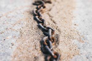 Close up of rustic chain in the sand