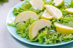 Close-up of salad with apples, grapes and lettuce in a blue plate (Flip 2019)